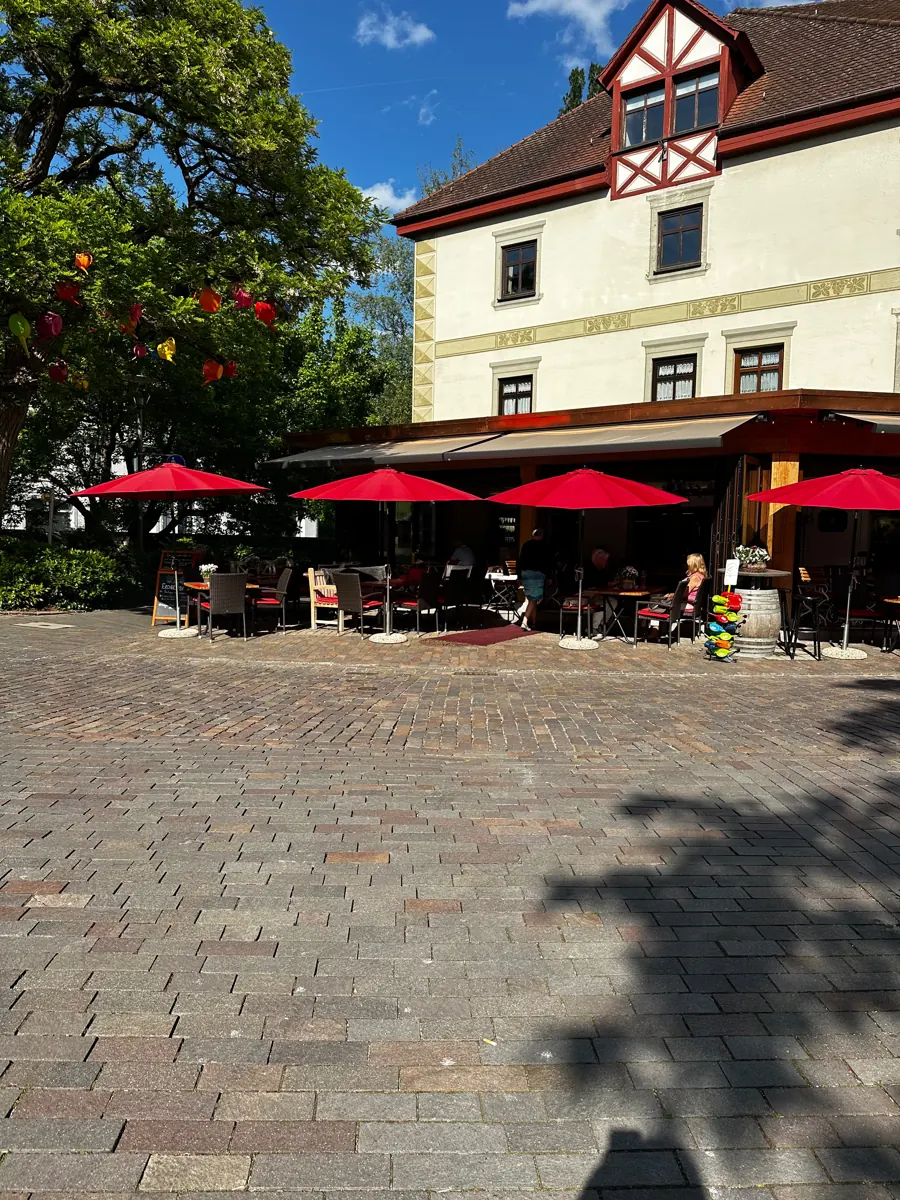 Das Weinhaus Renker im Sommer mit roten Sonnenschirmen auf der Terrasse